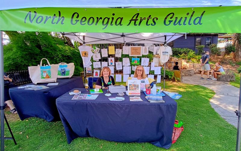 Megan Horn/The Clayton Tribune.  Jaye Masters And Cathy Jowers showcase beautiful artwork with the North Georgia Arts Guild at The Rock House in downtown Clayton during Ramshackle. The Arts Guild will have its annual Painted Fern Art Festival on Saturday, July 11, and Sunday, July 12, at the Rabun County Civic Center.
