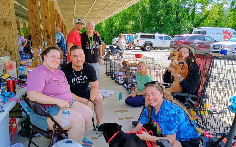 Megan Horn/The Clayton Tribune. Rabun Paws 4 Life was one of several nonprofits that participated in the June 13 Community Appreciation event. Many dogs and cats at the no-kill shelter are available for adoption. Pictured are Jessica Sozbee; Colton Sozbee; Jessie Gipson; Nathan Porter; Everett Lampros; Terrie Bogan; Lynzee Fountain. Volunteer Amanda Burrell also participated in the event. The dogs pictured and available for adoption are named  “Jessup,” “Ellie,” and “Daisy.”