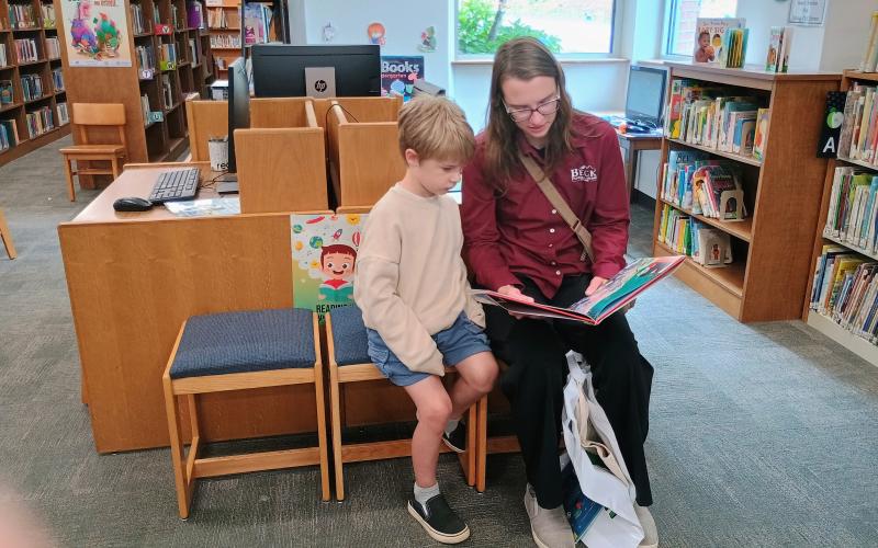 Megan Horn/The Clayton Tribune. Hannah Hightower reads a book to Ollie Hightower, 4, at the Rabun County Public Library kickoff for the 2026 Summer Reading Program “Unearth a Story.”