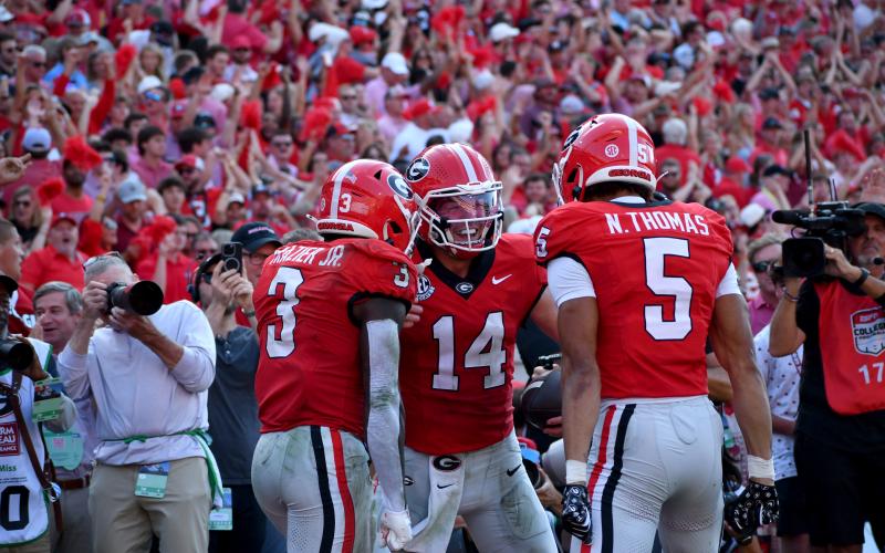 Wesley Branch/The Clayton Tribune. Former Rabun County and current UGA quarterback Gunner Stockton celebrates with teammates Nate Frazier Jr. (left) and Noah Thomas (right) after scoring a rushing touchdown during Georgia’s 43-35 win over Ole Miss at Sanford Stadium on Oct. 18, 2025. Stockton is heading into his final season of college football and his second season as Georgia’s starting QB.