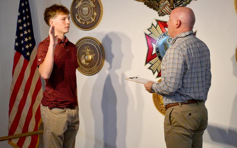 Wesley Branch/The Clayton Tribune. Huey Blalock (left) is administered his oath of service by Roger Glenn (right) at VFW Post 4570 in Clayton on June 24. Blalock and Glenn were joined by Blalock’s family, friends, teammates, coaches and several local veterans to celebrate Blalock’s oath of service.