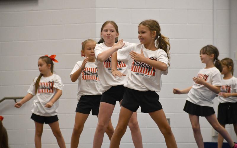Wesley Branch/The Clayton Tribune. Rabun County campers perform during the Rabun County cheer camp showcase on June 25 at Rabun County Elementary School. Pictured here, Wildcat campers Molly Blake (middle) Reeves Bragg (right) and Everly Youngblood (left) go through their routine during the showcase.