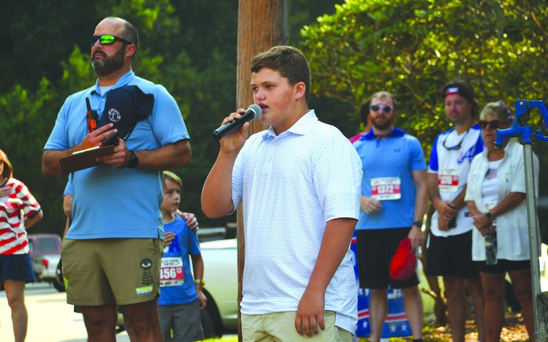 Wesley Branch/The Clayton Tribune. Eleven-year-old Hank Bramlett from Cornelia, Ga., sings The Star-Spangled Banner before the start of the Lake Burton Fun Run on July 4 at Moccasin Creek State Park.