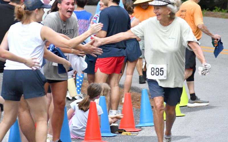 Enoch Autry/The Clayton Tribune. Shelley McDonald, 79, receives congratulations upon finishing the 5K.