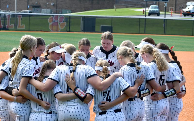 Wesley Branch/The Clayton Tribune. The Rabun County softball team gathers to pray before its 20-3 win over Tallulah Falls on Aug. 16, 2025. The Lady Cats enter 2026 with the themes, “Kick Ash” and “New team, Same game.”