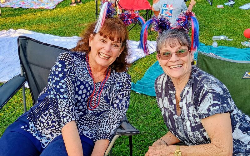 Megan Horn/The Clayton Tribune. Debbie Chisholm and Debra Miller enjoy activities at Clayton City Hall at the Stars Over Clayton Light Show Celebration July 1.