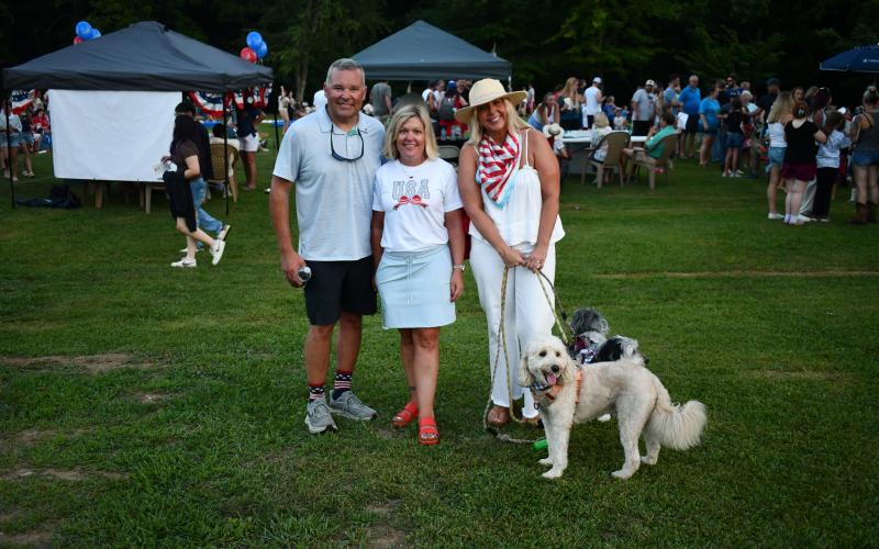 Megan Horn/The Clayton Tribune. Kyle Shook, left; Sonya Shook, president of the Clayton Merchants and Business Association (CMBA) and Kayla Flaherty with their dogs Henley and Bowie, enjoy the festivities at Clayton City Hall on July 1.