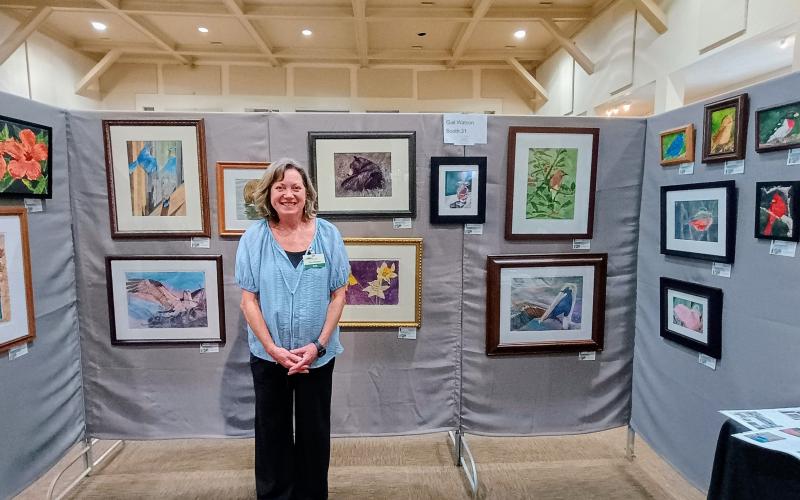 Megan Horn/The Clayton Tribune. Gail Watson features her artwork during the Painted Fern Art Festival at the Rabun County Civic Center last weekend.