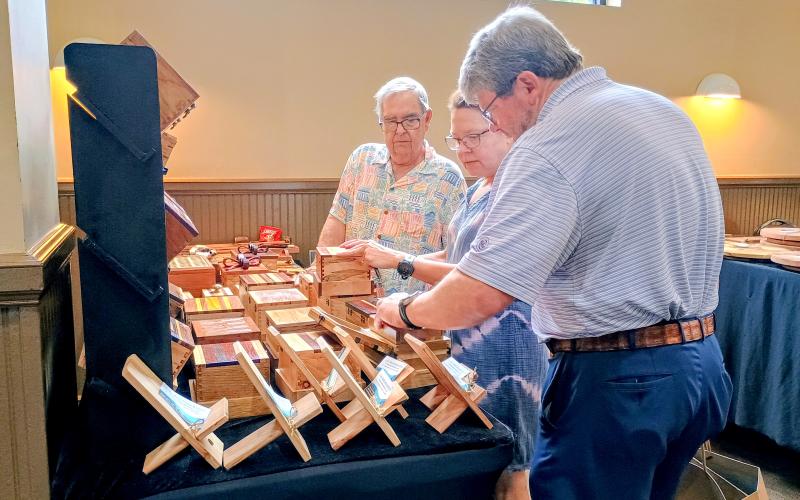 Megan Horn/The Clayton Tribune. Jerry Williamson talks to Painted Fern Art Festival visitors John and Mary Ray about his J.W. Wood Boxes &amp; Gifts last weekend. The festival was presented by the North Georgia Arts Guild.