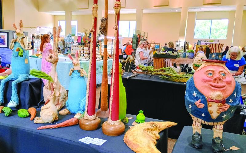 Megan Horn/The Clayton Tribune. Paper mache artist Judy Schmidt with her “Paper Trails” is this year’s winner of the Painted Fern Art Festival “Peoples’ Choice Award for Best in Show.” Her booth featured many of her paper mache characters including cartoon character “Humpty Dumpty,” a crescent moon, rabbits and many others.