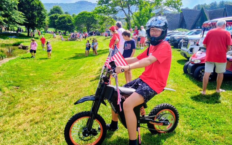Megan Horn/The Clayton Tribune. Mason Collins, 15, rides around Sky Valley wearing red, white and blue during Independence Day events on Friday, July 3.
