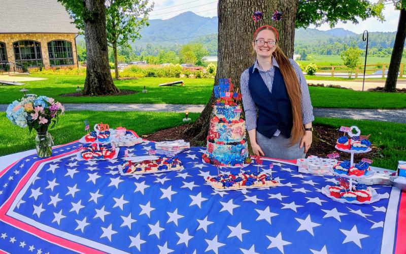 Megan Horn/The Clayton Tribune. Dillard House: A Mountain Farm Resort employee Aliye Coker stands beside America’s 250th birthday cake that was baked for the special Independence Day celebration on July 4. The restaurant held events all weekend and offered its barbecue menu.
