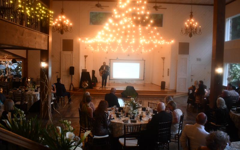 Megan Horn/The Clayton Tribune. Aaron Hooker plays a worship set during the Choices Pregnancy Center Heartbeat Gala on Aug. 1 at Chota Falls. Gala guests sang along and praised God with hands in the air. The venue was beautifully lit and decorated.