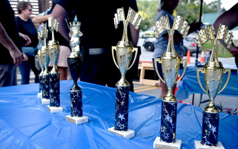 Enoch Autry/The Clayton Tribune. Trophies were awarded to the top three finishers in the Youth Division and Adult Divsion at the Aug. 8 soapbox derby in Clayton prior to the downtown block party.
