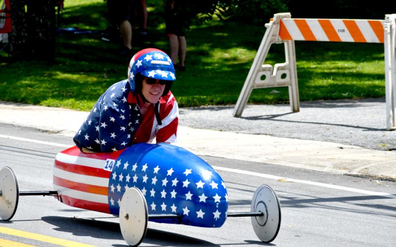 Enoch Autry/The Clayton Tribune.  In the adult division of the Aug. 8 soapbox derby, the “Stars &amp; Stripes” car claimed the top spot as it was driven by Derrick Reynolds.