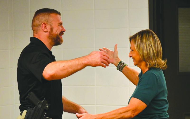 Enoch Autry/The Clayton Tribune. Clayton City Manager Trudy Crunkleton (right) prepares to give Kevin Marsteller a hug after the city council unanimously approved the current major with the Corneila Police Department as Clayton’s new police chief. Marsteller will succeed Michael Turner, who has announced his resignation effective Aug. 28.
