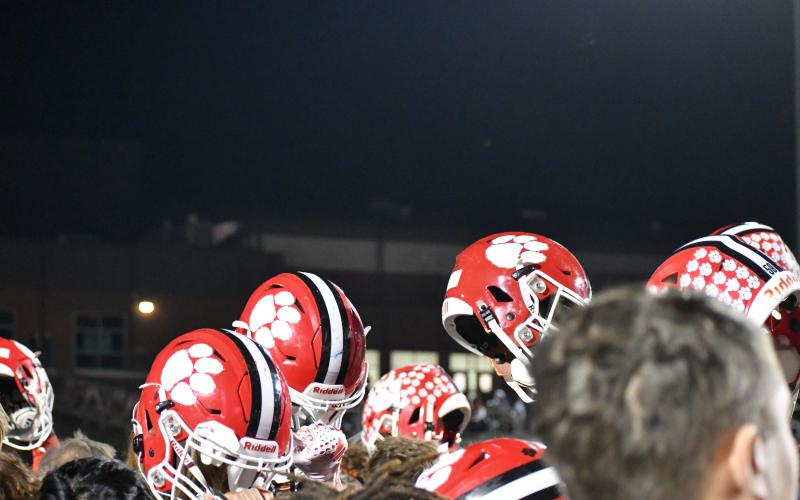 Wesley Branch/The Clayton Tribune. Rabun County players hoist their helmets as they break down their postgame meeting on the field following their 56-21 first-round playoff win over Dodge County on Nov. 14, 2025. The Wildcats’ victory over the Indians was the first RCHS home playoff win since 2022.