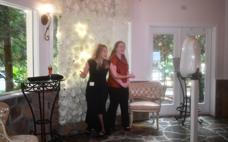 Megan Horn/The Clayton Tribune. Ashley Ownbey and Elaina Hill-Hooker, administrative coordinator for Choices Pregnancy Center, enjoy taking fun pictures in the photo booth at last weekend’s Heartbeat Gala. The photo booth was sponsored by Jubilee Balloon Art + Event Rentals from Murphy, N.C.