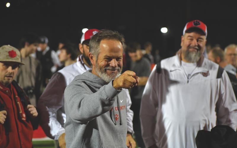 Wesley Branch/The Clayton Tribune. Rabun County head football coach Rance Gillespie celebrates with his team after the Wildcats’ 35-0 second-round playoff win over Berrien on Nov. 21, 2025. Gillespie and the Wildcats have celebrated each win at home with the song “It’s a Great Day to Be Alive,” since former head coach Lee Shaw started the tradition in 2013. Standing in the background are Manager Josh Justus, Pastor Lance Courtney and current Rabun County Athletics Booster Club President Joey Haban.