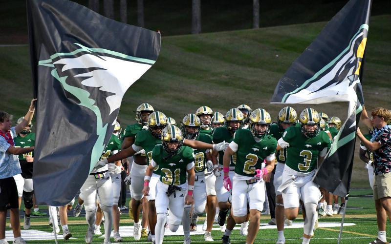 Wesley Branch/The Clayton Tribune. Rabun Gap’s football team runs onto the field ahead of its regular season game versus Christ School last season. The Eagles will scrim- mage Westside (S.C.) on Aug. 14, before opening the season Aug. 21.