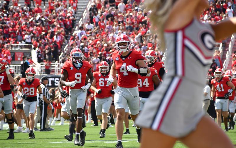 Wesley Branch/The Clayton Tribune. The Georgia football team runs onto the field ahead of its home-opening game versus Marshall last season. The Bulldogs, who open the new season versus Tennessee State on Sept. 5, earned the No. 3 ranking in the preseason Associated Press poll.