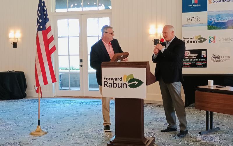 Megan Horn/The Clayton Tribune. Rick Story, president of Forward Rabun/Rabun County Chamber of Commerce and director of development, right, thanks Forward Rabun Chairman Claude Dillard for his seven years of service as he passed the gavel to Chairman-Elect Steven Cole. Story presented Dillard him with a framed gavel with a name plate featuring the Forward Rabun logo and that reads “With Great Appreciation.”