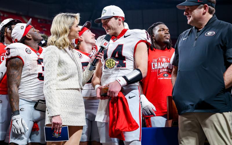 Keith Barlow/CNI News Service. Holding his MVP trophy with his teammates and head coach Kirby Smart on the stage with him, Georgia quarterback Gunner Stockton answers questions from Laura Rutledge after the Bulldogs’ 28-7 win in the SEC championship game on Dec. 6, 2025.