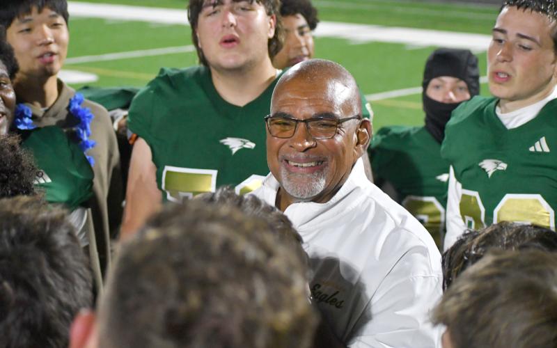 Wesley Branch/The Clayton Tribune. Rabun Gap defensive line coach Joe Crosby smiles as the RGNS football team wishes him a happy 70th birthday after their regular season win over Christ School last season. Crosby has been coaching at Rabun Gap for six years.