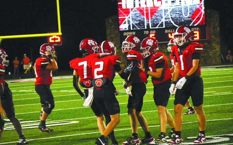 Enoch Autry/The Clayton Tribune. Colter Cannon, center, is congratulated by his teammates after making an interception against Metter in the Wildcats’ 27-23