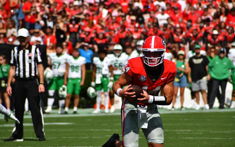Wesley Branch/The Clayton Tribune. In his first regular-season game as a starter, Bulldog quarterback Gunner Stockton of Tiger pulls the ball down on a scramble against visiting Marshall on Aug. 30, 2025. Georgia opens its 2026 season again at home as Tennessee State comes to Athens.