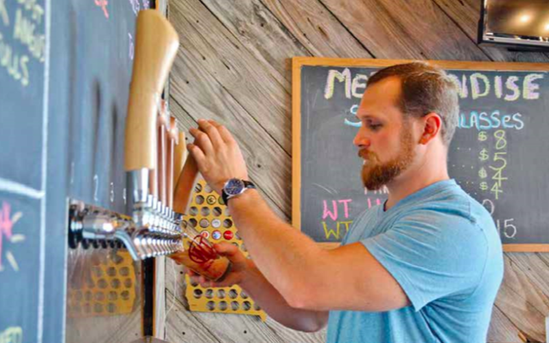Christina Santee/ Scott Hulsey pours a glass full of one of his crisp, handcrafted beers in the brewery he owns with is father, Gary Hulsey.