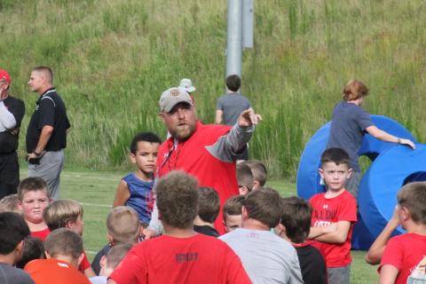 Rabun County running backs coach Andy Mahaffey directs players toward the next position station during the football team’s Future Wildcats Camp at the team’s practice field in Tiger on Monday night. (Glendon Poe/The Clayton Tribune)