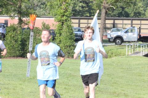 Anthony Lampros, left, and Guy Gober near the finish line at Rabun County’s new pavilion during the Bicentennial Torch and Flag Run in Clayton on Saturday morning. (Glendon Poe/The Clayton Tribune)