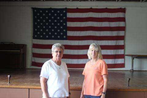 Grace Watts, mayor of Mountain City, left, and Brenda Cannon, city clerk, stand in front of the stage on new flooring at Mountain City's city hall where the Bicentennial square dance will take place on Saturday, July 20