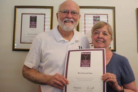 Megan Broome/The Clayton Tribune. David Darugh, left, and Gayle Darugh, hold up their award for having Beechwood Inn honored for its wine program with the Wine Spectator Restaurant Award of Excellence for 2019. They have been a consecutive winner of the award since 2007. 