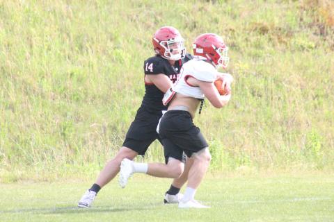 Rabun County quarterback Gunner Stockton, left, hands the ball off to running back Brody Jarrard during a practice in May. (Glendon Poe/The Clayton Tribune)