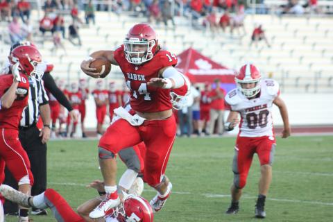 Rabun County quarterback Gunner Stockton (14) leaps a fallen Franklin (N.C.) player during a touchdown run in the second quarter of a preseason game at Frank Snyder Memorial Stadium in Tiger last Friday night. (Glendon Poe/The Clayton Tribune)