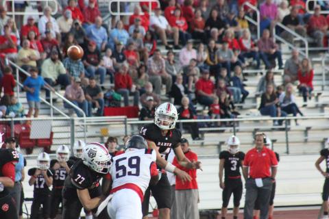 Rabun County quarterback Gunner Stockton (14) eyes his intended receiver as offensive lineman Chris Thompson (77) blocks Putnam County defensive lineman Trevon Farley during the first half at Frank Snyder Memorial Stadium in Tiger last Friday night. (Glendon Poe/The Clayton Tribune)