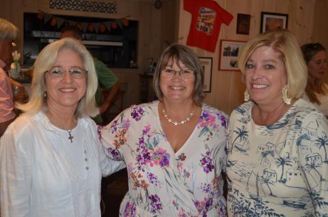 Wayne Knuckles/The Clayton Tribune. Tourism Development Authority Executive Director Teka Earnhardt, center, is greeted by Daphne Lisenby of Wolffork Valley Farms (left) and TDA board vice-chairman Laura Gurley at a reception Tuesday at Clayton Café. 