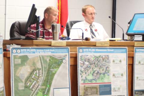 Megan Broome/The Clayton Tribune. Mayor Green, left, and city attorney Mitch Baker listen as Heather Feldman, representative from Georgia Mountains Regional Commission (GMRC), talks to city council members about GMRC’s plan to update the city of Clayton’s Charter and the Clayton city council meeting Tuesday. 