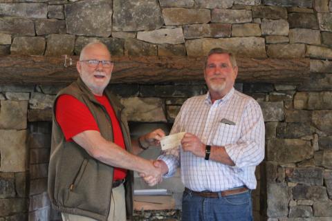 Megan Broome/The Clayton Tribune. Rocky Ford, left, President of Rhapsody in Rabun, presents a check to Dan McAfee, President of Habitat for Humanity of Rabun County, from the proceeds of the Rhapsody in Rabun Gala at an event held at the Lake Rabun Pavilion recently.