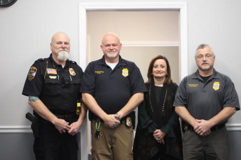 Megan Broome/The Clayton Tribune. Lt. Ron Baumes, police officer, left, Vaughn Estes, chief of police, Ella Fast, city manager and Lt. David Edwards, police officer, stand inside the newly renovated Sky Valley Police Department building at an open house for the City of Sky Valley on Thursday, Dec. 19. Edwards completed the renovation project. 
