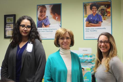 Megan Broome/The Clayton Tribune. Amerigroup Community Care sponsored “Diaper Day” on Tuesday, Jan. 28 at the Rabun County Health Department. From left, Sarah Pedraza, representative from Amerigroup, Sue Darnell, office manager for the Rabun County Health Department, and Lacy Carter pose in front of a table of donated diapers at the “Diaper Day” event. 