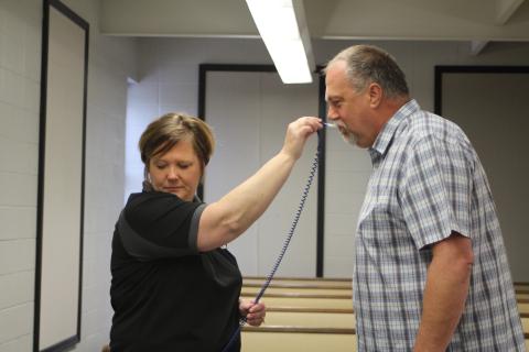Megan Broome/The Clayton Tribune. Lt. Misty Houston, left, takes the temperature of Council Member John Bradshaw before Monday's special called Clayton City Council meeting discussing COVID-19 concerns. 