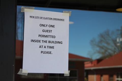 Megan Broome/The Clayton Tribune. Fortify Pi, a restaurant located on Main Street in Clayton, has this sign posted on their window Wednesday afternoon.The Clayton council proclaimed that businesses operating inside the city should limit the number of people in their establishments at any one time to one person per 100 square-feet of floor space, not including store employees.