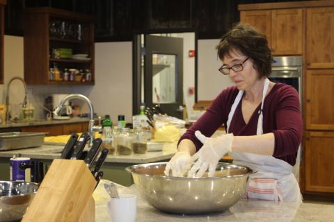 Megan Broome/The Clayton Tribune. Inger Smith, Teaching Kitchen manager, works with Food Bank staff and volunteers in the kitchen to prepare meals for first responders and healthcare personnel on Wednesday. 