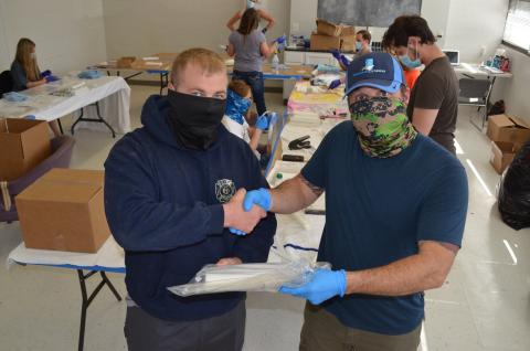 Wayne Knuckles/The Clayton Tribune. Clayton Mayor Jordan Green, left, signed an agreement with Shaun Brautigan Monday to allow his company to use the city's Community Room to produce face shields.