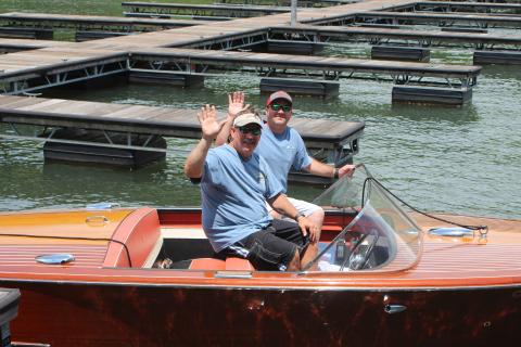 Megan Broome/The Clayton Tribune.Fred Beck, left, and Hunter Hargrave showcase Beck’s 1959 Chris Craft wooden boat named “Tallulah” at LaPrade’s Marina following Lake Burton’s first-ever Wooden Boat Parade. The whole boat is completely original and has been on Lake Burton its entire life. 