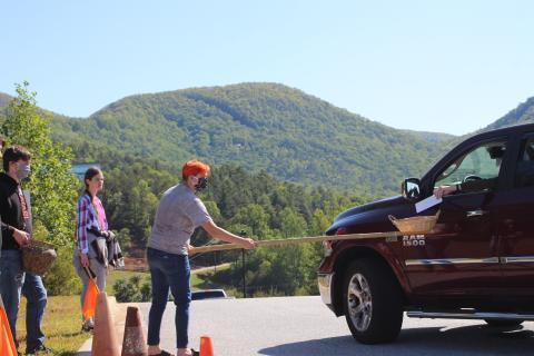 Megan Broome/The Clayton Tribune.Peyton Fisher, left, Heidi Gardner and Jalyn Fisher collect offerings as churchgoers of Clayton First United Methodist Church leave following the first drive-in church service held on Ministry Mountain on Sunday. 