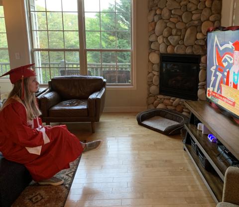 Photo courtesy Grace Nolan. Grace Nolan wears her cap and gown while watching the virtual commencement addresses from fellow classmates. 